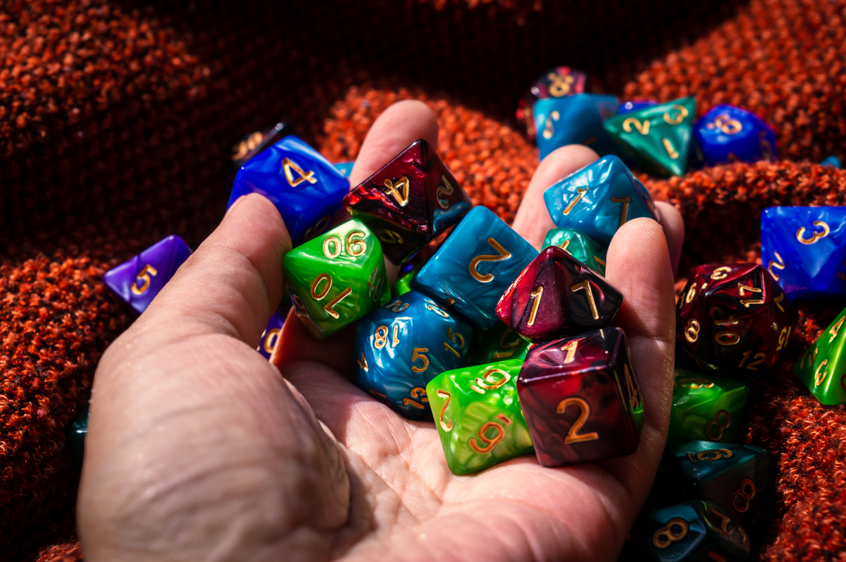 Hand holding various RPG game dice